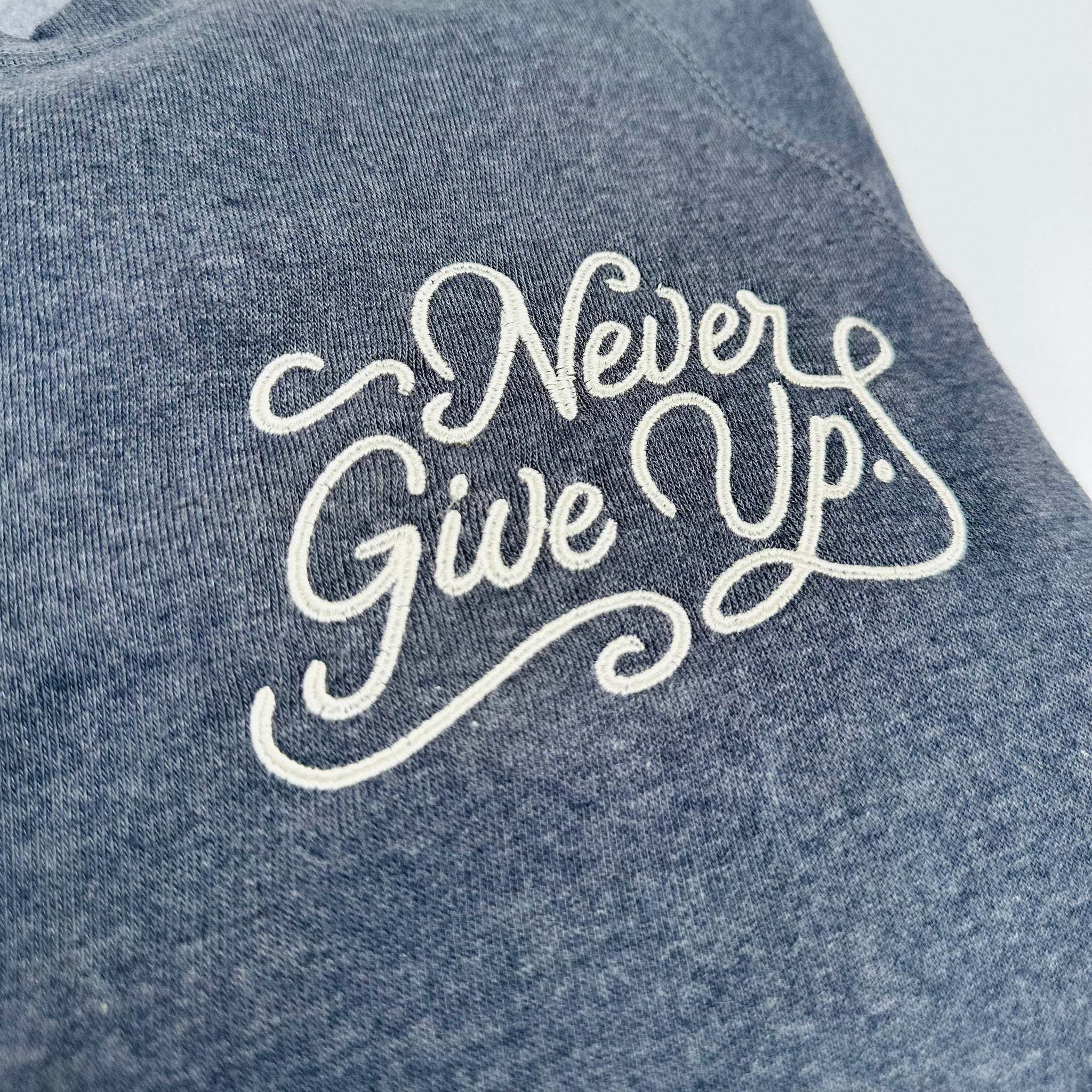 EMBROIDERED NEVER GIVE UP. NAVY PULLOVER