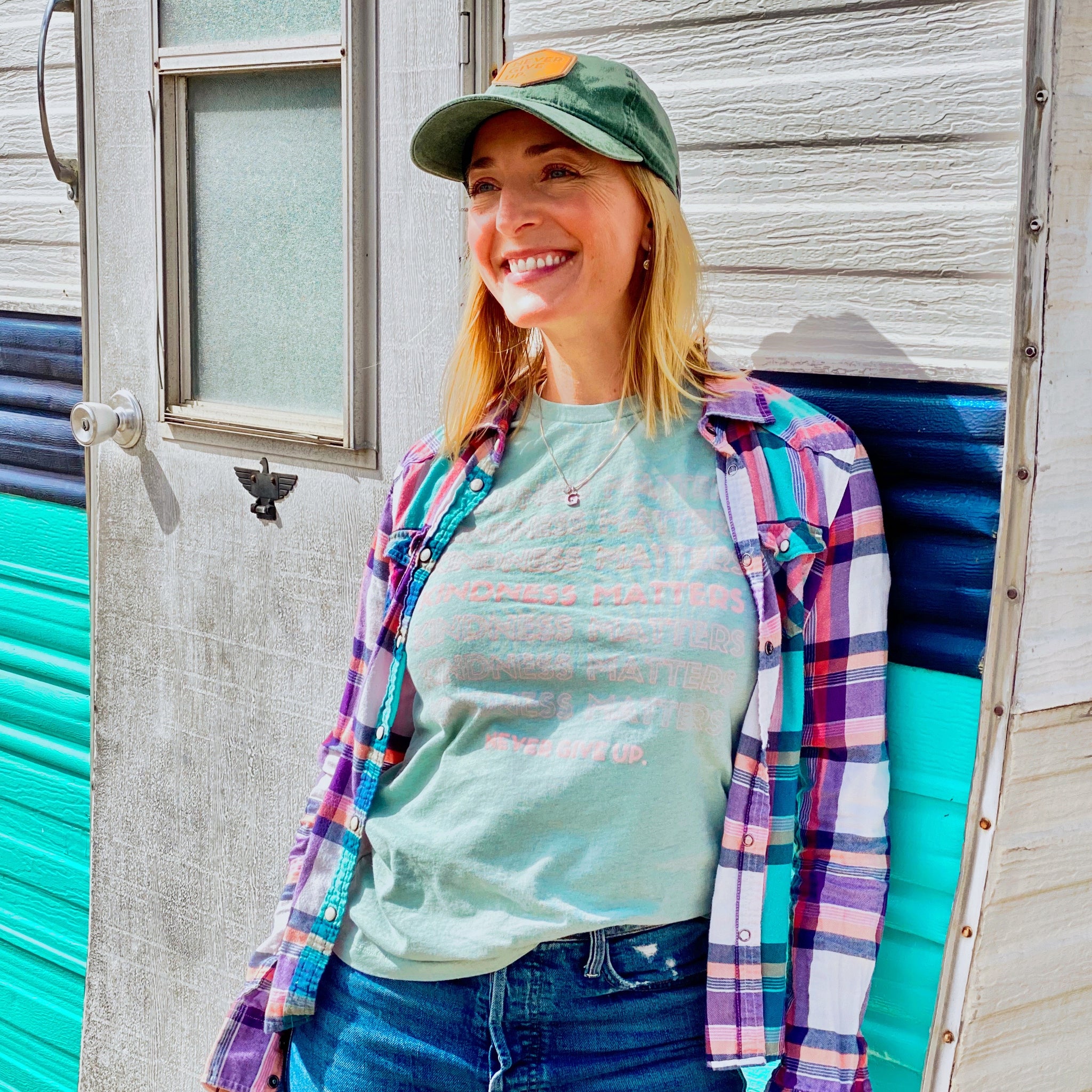 Woman wearing green NEVER GIVE UP. leather patch hat