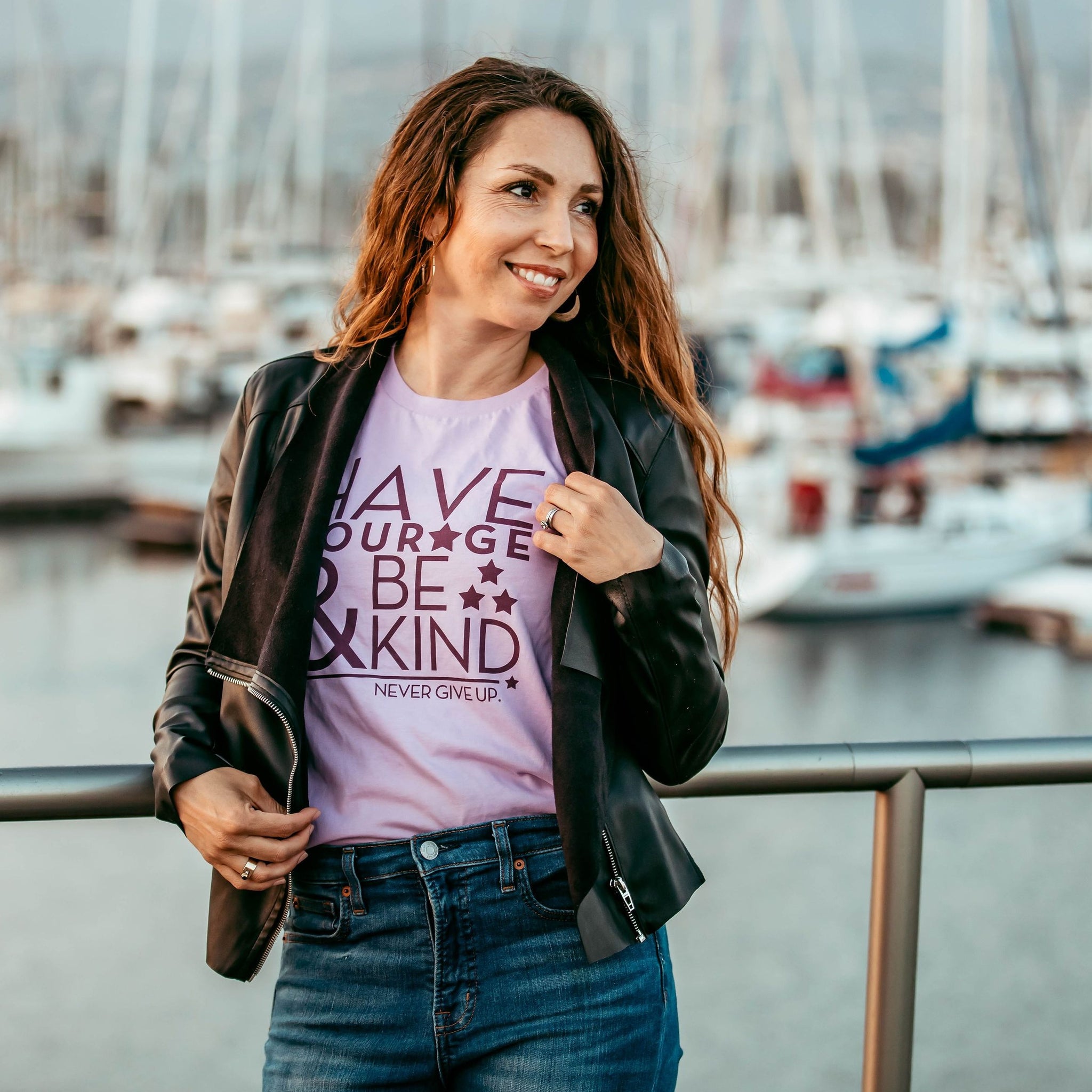 woman standing in lilac tee that says Have Courage & Be Kind